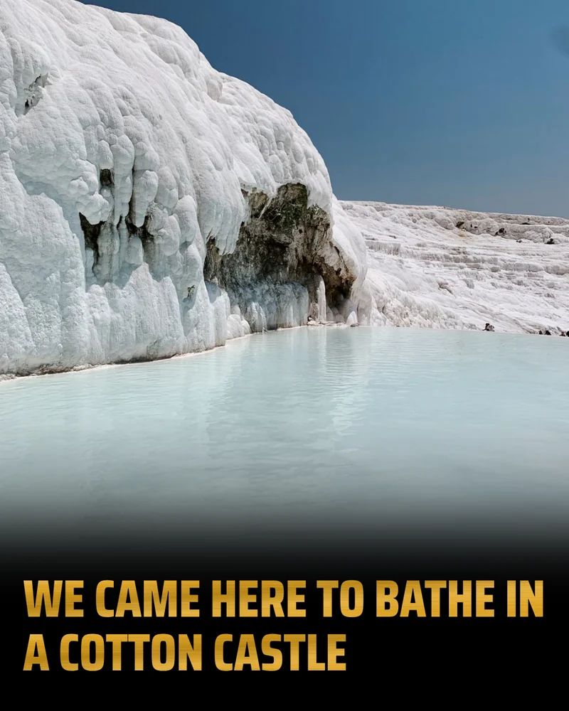 A Broadcast slide: gold capitals reading “We came here to bathe in a cotton castle” on a black band under a photograph of pale blue water pooled against Pamukkale’s white travertine.